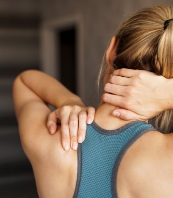 spoerty female holding shoulder in pain